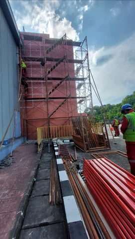 Menara scaffolding oranye terpasang di sisi dinding bangunan
